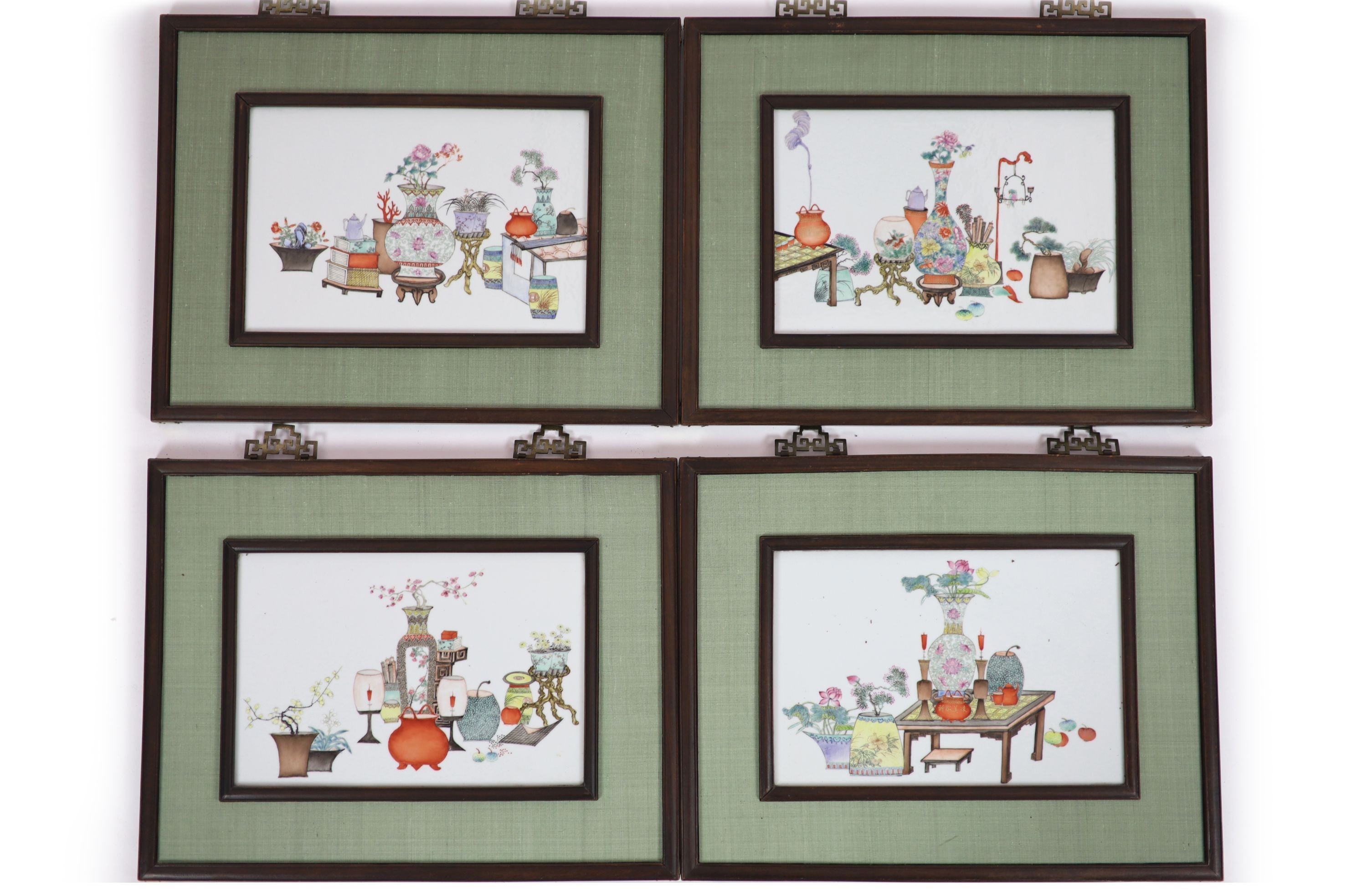 A set of four Chinese famille rose 'Hundred Antiques' plaques, late Qing dynasty, porcelain 26cm x 39cm, in hongmu and silk frames with jichimu insets to the back